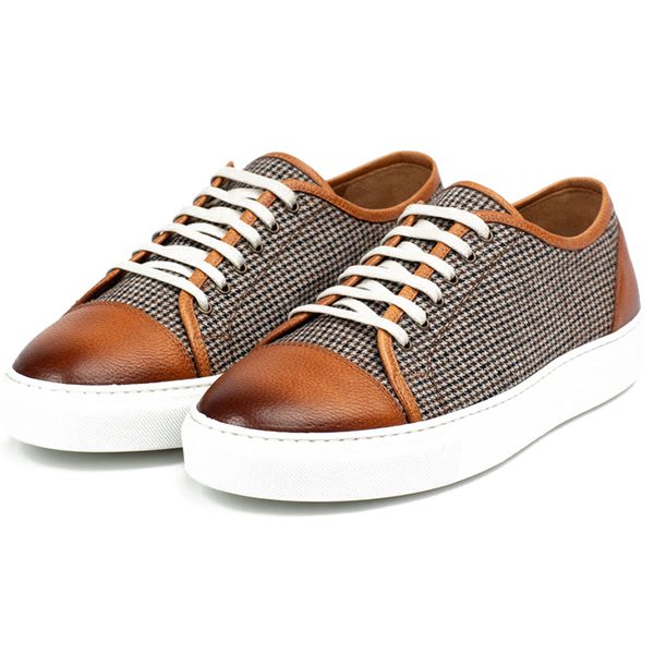 Brown leather and houndstooth-patterned sneakers with white laces and white soles, featured in the duPont REGISTRY. Keep an eye out for the biggest savings on Black Friday 2024.