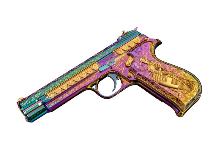 A colorful, elaborately engraved pistol with gold accents and ornate patterns on the handle and slide.