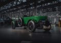 A vintage green Bentley from the Continuation Series rests elegantly indoors in a spacious, industrial-style garage with large windows and overhead lighting.