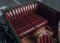 The interior of a Bentley Speed Six features a brown leather bench seat with vertical stitching, surrounded by dark green vehicle trim, capturing the elegance of its Continuation Series heritage.