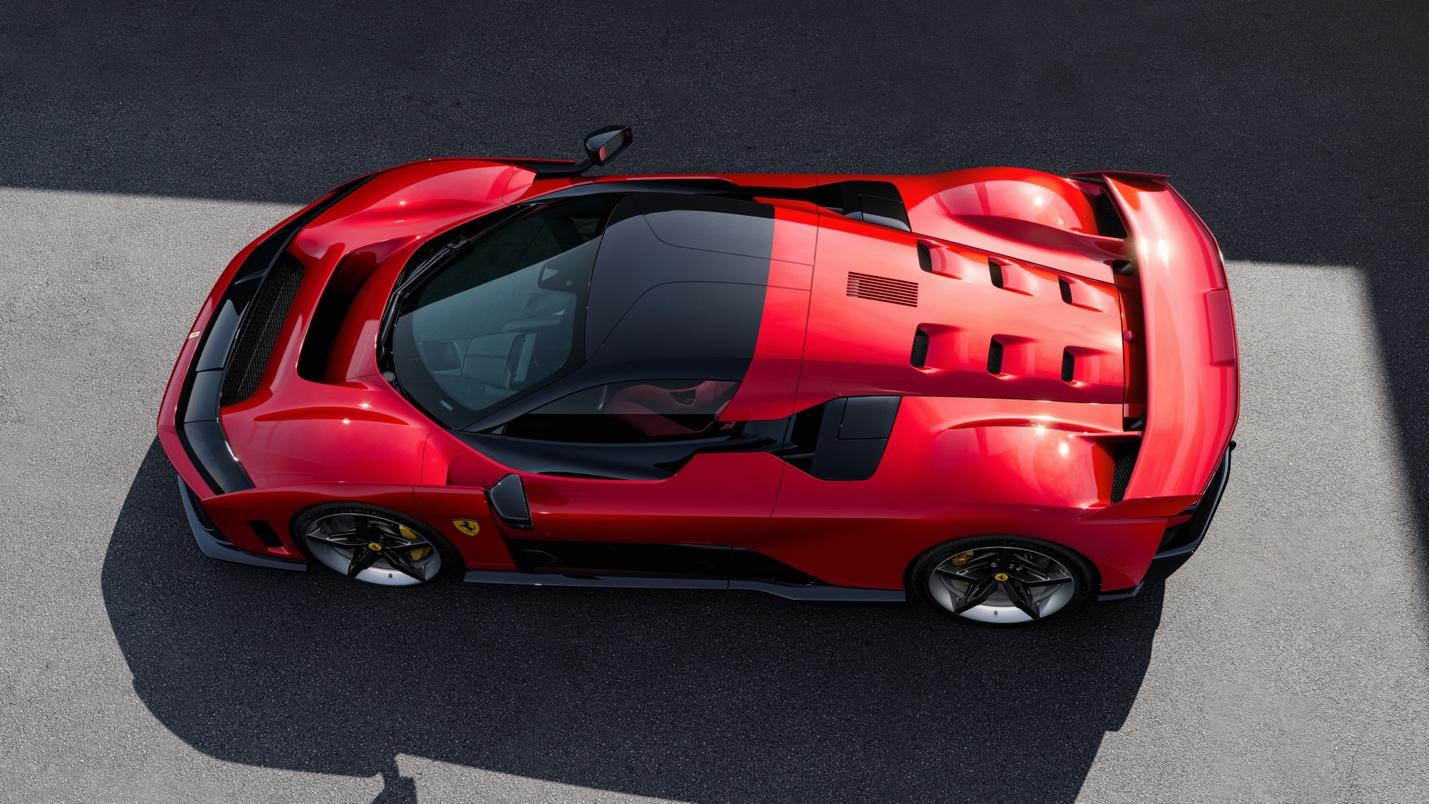 A striking Ferrari F80, with its sleek design, is viewed from above, parked on the gray asphalt surface.