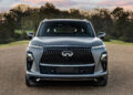 A silver Infiniti SUV is parked on a gravel surface with trees in the background, embodying tailgating luxury.