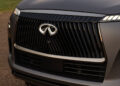 Close-up of a car's front grille featuring the Infiniti logo and a sleek, metallic design, epitomizing luxury.