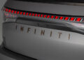 Close-up of a sleek car's rear, featuring the signature "INFINITI" branding and distinctive red tail light design on a gray surface, embodying the essence of tailgating luxury.