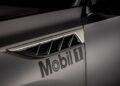 Close-up of a car's side panel displaying the "Mobil 1" logo and a sleek vent design, reminiscent of Infiniti's signature elegance.