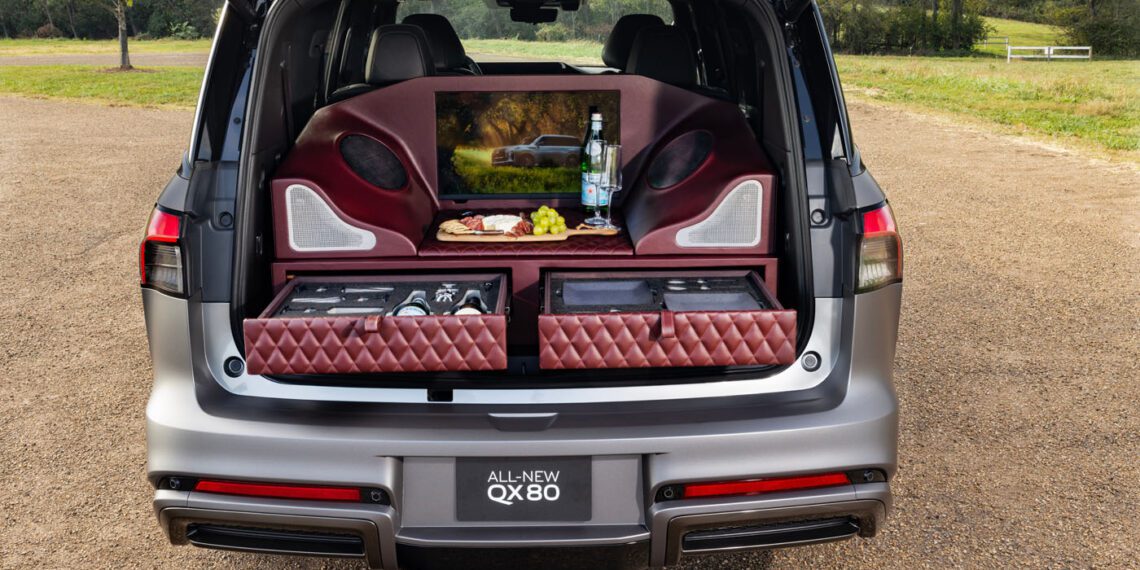 The Infiniti car trunk transforms into a Tailgating Luxury experience, featuring padded shelves, a screen, and an array of beverages and snacks on display, mimicking an AUTOGRAPH Lounge Concept.