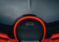 Close-up of a Bugatti W16 Mistral car grille with a carbon fiber finish and an orange outline, echoing the open-top speed record of 282.05 MPH.