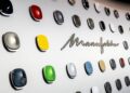 A wall display of various car paint samples in different colors, showcasing Mercedes-Benz’s customization options with the word "Manufaktur" in metallic script, reminiscent of a visit to the MANUFAKTUR Studio.
