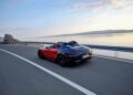 A Mercedes-AMG convertible sports car races along the coastal road, revealing breathtaking views of the sea and distant mountains beneath a cloudy sky, capturing the essence of PureSpeed.