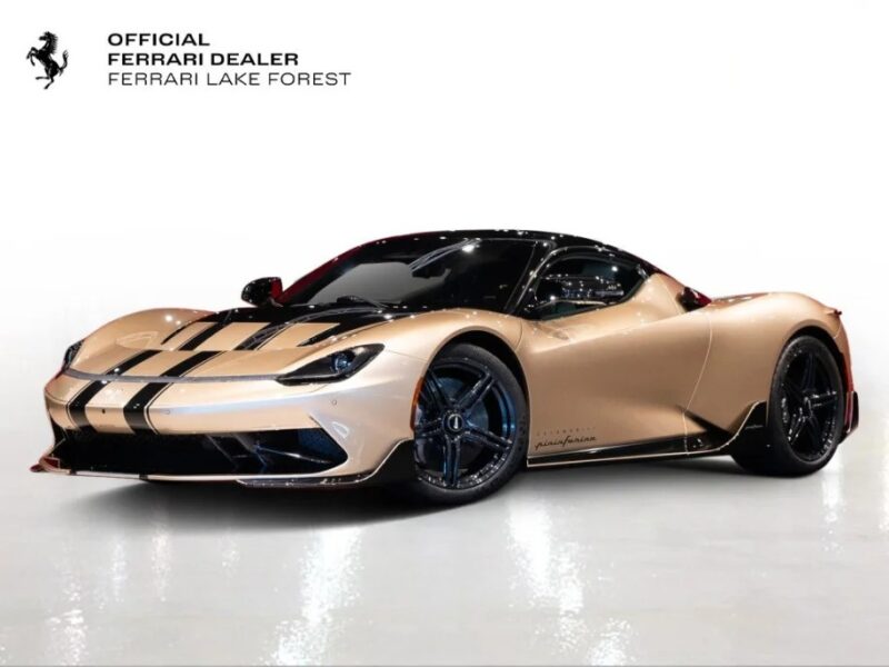 A gold-toned Ferrari sports car with black racing stripes sits against a white background. In the top left corner, the text reads "Official Ferrari Dealer, Ferrari Lake Forest." This stunning vehicle embodies luxury and performance, and it's now for sale alongside exclusive models like the Pininfarina Battista electric hypercar.