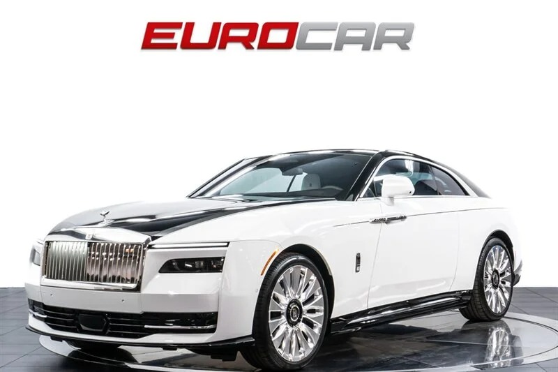 A stunning white Rolls-Royce Spectre, an ultra-luxe electric super coupe, is displayed on the showroom floor, with the logo "EUROCAR" proudly above.