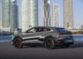 A custom-designed Lamborghini Urus SE luxury SUV is parked near a body of water, with the city skyline and modern skyscrapers in the background, setting the stage for Art Basel 2024.