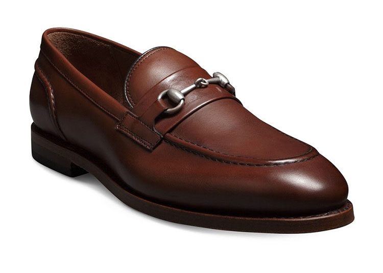 A brown leather loafer with a metal bit detail across the top, perfect for discerning gentlemen seeking luxury gifts.