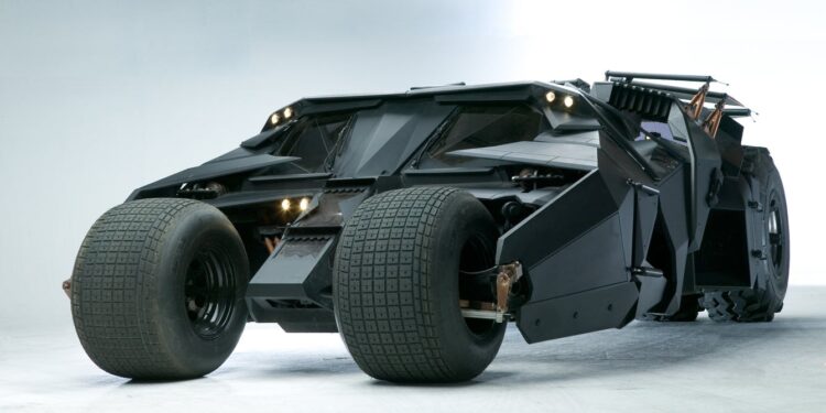 Futuristic black Batmobile armored vehicle with large tires, angular design, and multiple headlights, set against a plain background.