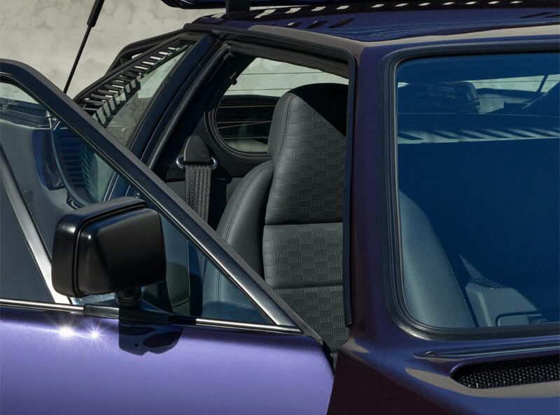 Close-up of an open car door showcasing the driver's seat and side mirror, with sunlight glinting off the purple exterior of this exclusive KITH BMW M1 collaboration.