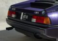 The rear view of a purple BMW M1 features iconic "Kith" branding, designed in collaboration with Ronnie Fieg, and a Florida license plate reading "JUST US.