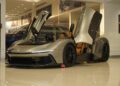 A sleek silver sports car with butterfly doors open is displayed indoors on a shiny floor at Braman Motorcars, capturing the essence of Palm Beach luxury.