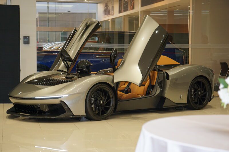 A sleek silver sports car with its butterfly doors open, displayed at Braman Motorcars in Palm Beach, boasting a luxurious interior design reminiscent of Automobili Pininfarina's elegance.