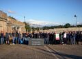 A group of people outdoors, raising their arms in celebration next to a sign displaying an impressive time of 06:57.685, mark the Ford Mustang GTD's stunning achievement at the Nürburgring, proudly conquering the track in under 7 minutes.