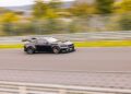 A sleek black Ford Mustang GTD speeds around the legendary Nürburgring race track, capturing motion with a blurred background as it aims for a lap time under 7 minutes.