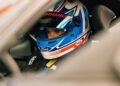 Inside the cockpit of a Ford Mustang GTD, a racer in a helmet sits intently, eyes focused on conquering the Nürburgring in under 7 minutes.