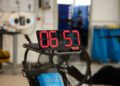 In a workshop setting with tools and equipment in the background, a digital timer displays 06:57—just under 7 minutes. It's reminiscent of the high-speed precision expected from a Ford Mustang GTD at the Nürburgring.