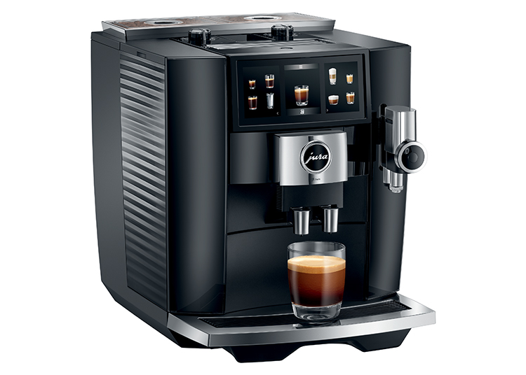 A black coffee machine from the 2024 Holiday Gift Guide elegantly dispenses espresso into a clear glass.