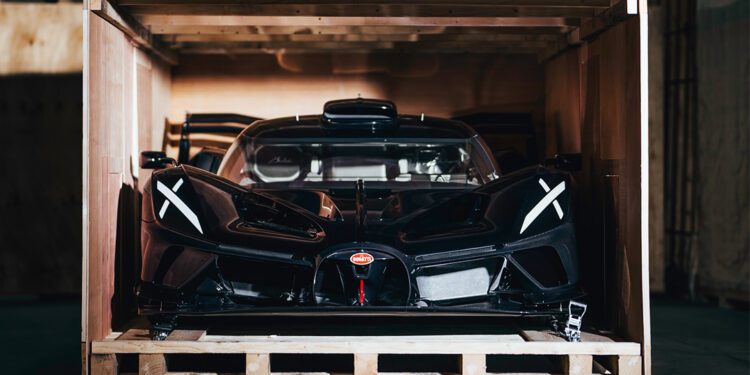 Tucked securely within the wooden crate, a sleek black Bolide Hypercar from Bugatti peeks out, hinting at its breathtaking design and power.