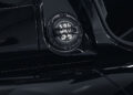 Close-up of a Praga supercar's glossy black exterior, focusing on the Bohema's round, metal fuel cap with intricate detailing.