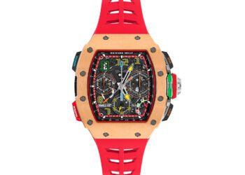 This luxury watch, reminiscent of the Richard Mille RM 65-01, boasts a red strap and a complex dial with multiple subdials, colorful accents, and intricate mechanical details.