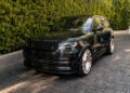 A custom-built Range Rover L460 sits elegantly on a stone driveway, flanked by lush green hedges. It's the kind of sleek sophistication that even Scott Disick would admire.