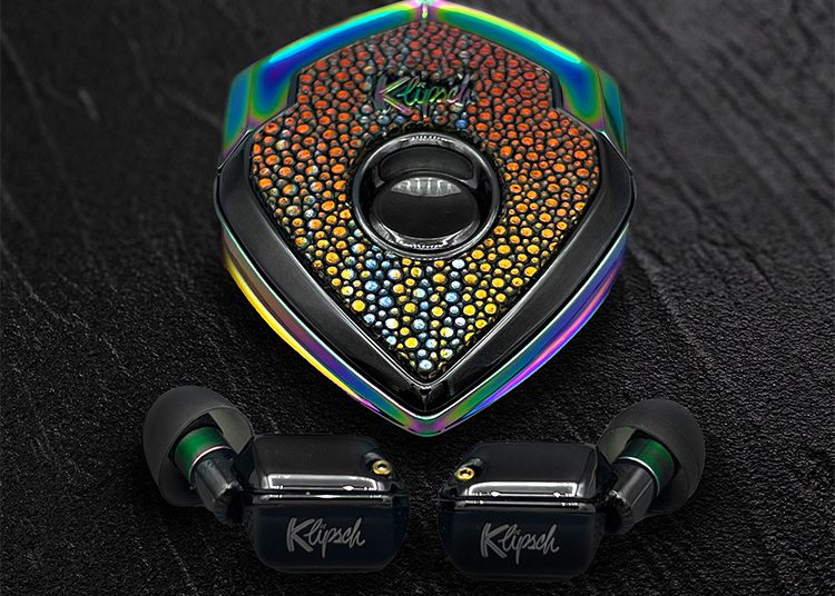 Discover the vibrant Klipsch earphones and their shield-shaped case, featuring a perforated, multicolor design perfect for any dark surface. Highlighted in the 2024 Holiday Gift Guide by duPont REGISTRY, these earphones make an ideal present for those who cherish both style and sound quality.