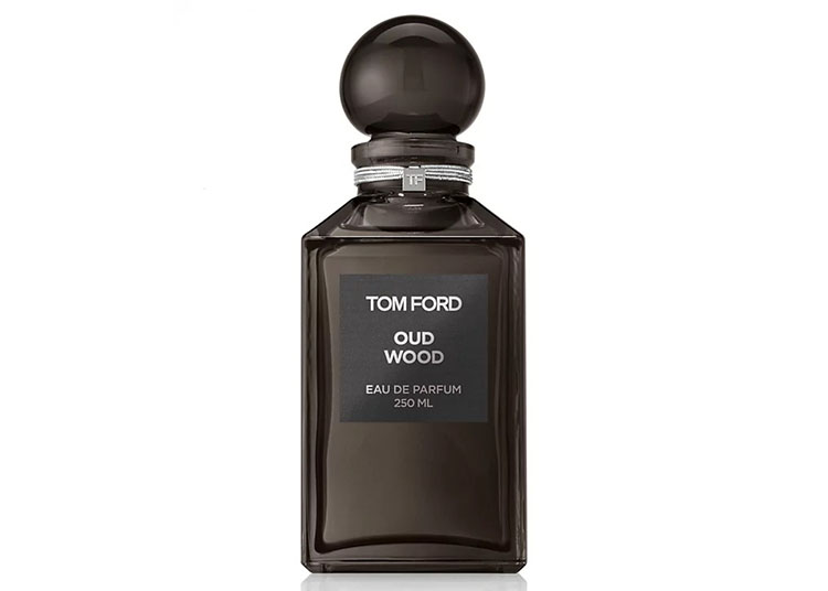 A dark glass bottle of Tom Ford Oud Wood Eau de Parfum, 250 ml, exudes elegance for gentlemen. With a round cap and the label proudly displayed on the front, it makes an exquisite luxury gift.