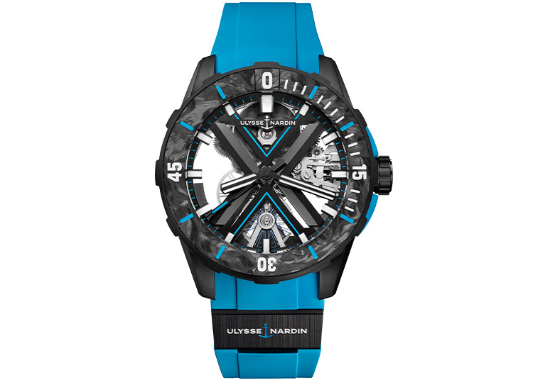 A wristwatch with a blue silicone strap and black carbon-fiber case, featuring a transparent gear design and bold white numerals, makes a striking addition to the 2024 Holiday gift guide in duPont REGISTRY.