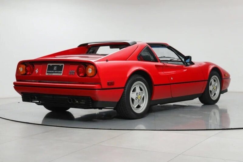 A red classic sports car with a Targa top, viewed from the rear on a white background, embodies the timeless allure of the Ferrari 328 GTS. This image captures not just elegance but also an iconic investment for enthusiasts seeking data-driven insights into automotive excellence.