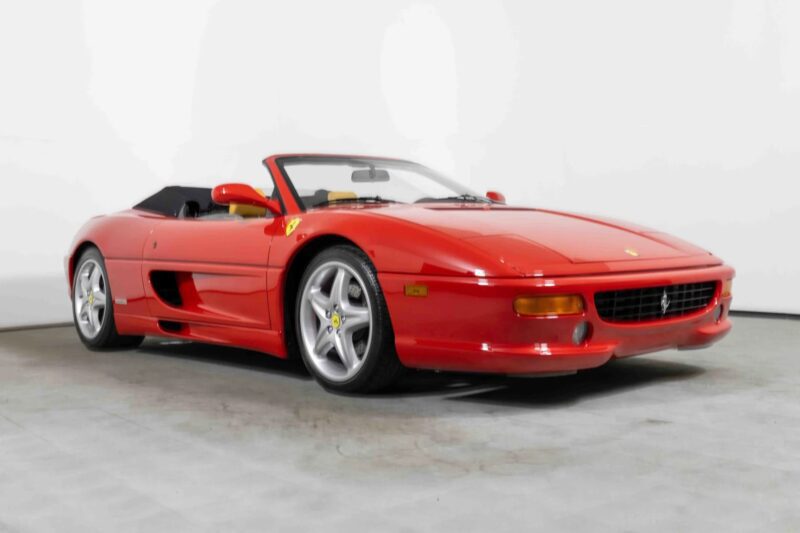 A red Ferrari convertible sports car with the top down, shown in a studio setting with a white background, captures the nostalgia of classic 90s cars for sale and showcases a piece of automotive history.
