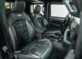 Interior view of a Rezvani Hercules 6x6 showcases black leather seats and visible stitching. The driver's seat and passenger seat are displayed, along with the steering wheel and dashboard. This stunning vehicle is now available for sale.