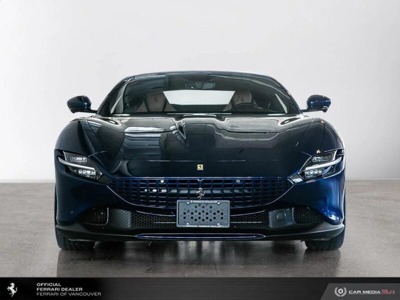 Front view of a dark blue Ferrari sports car in a showroom, showcasing its grille and headlights—an exotic car epitome that's now available for sale.