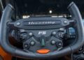 Close-up of a car steering wheel with "Hennessey" branding, various controls, and "F5" in the center, showcasing the exquisite craftsmanship of the Hennessey Venom F5 Roadster.