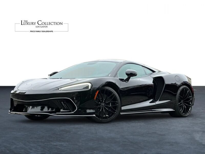 Exotic black sports car parked on a plain background with "The Luxury Collection Los Gatos" logo in the top left corner, showcasing its elegance as part of our luxury car listings.