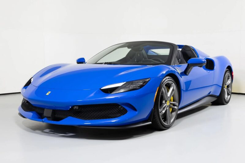 This exotic blue sports car, with its sleek design, low profile, and sporty wheels, is parked in a bright, minimalistic indoor space. Perfect for luxury car enthusiasts searching through for sale listings.