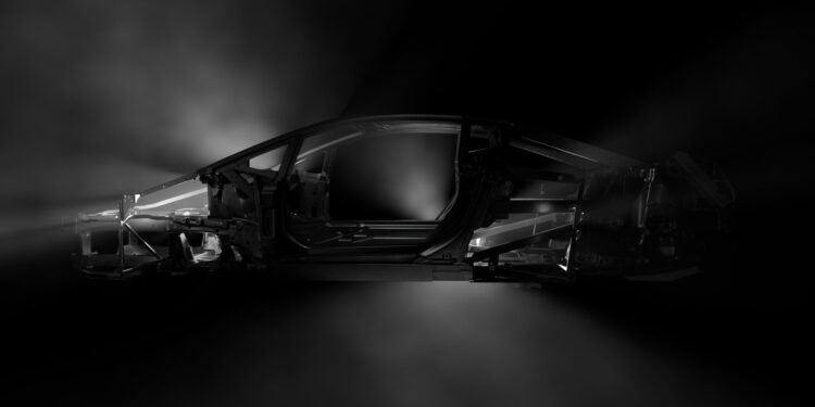 Side view of a Temerario car frame in dark lighting, highlighting its lightweight spaceframe structure and contours.