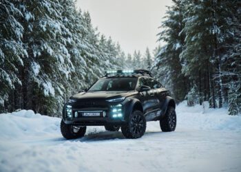 A new unveiling reveals the sleek Audi Q6 e-tron, an offroad concept parked gracefully on a snow-covered forest road, its black SUV body accented with roof lights and surrounded by towering pine trees.