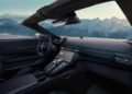 The interior of the Vantage Roadster features a modern car design with a digital dashboard and sleek controls, set against a backdrop of snowy mountains.