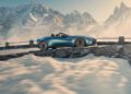 A blue Aston Martin Vantage Roadster gracefully navigates a mountain road, with snowy peaks painting the backdrop.