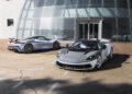 Two sleek, silver Automobili Pininfarina sports cars are parked outside a modern glass building on a sunny day, embodying groundbreaking design and setting the stage for 2024's automotive innovations.
