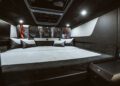 Luxurious interior of a BRABUS Shadow 1200 spacious sleeper cab featuring a large bed, padded walls, soft lighting, and overhead storage.