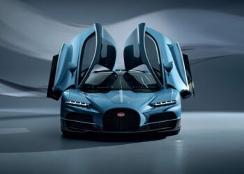 The Bugatti sports car, envisioned by Director of Design Frank Heyll, features striking blue hues and open butterfly doors, showcased against a blurred, abstract background.