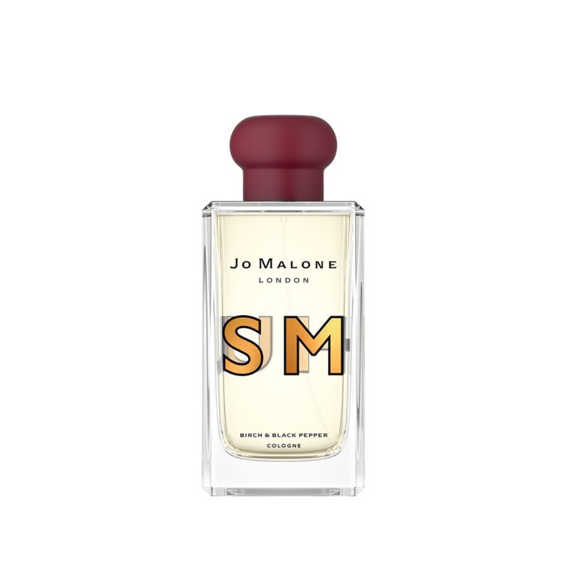 Discover the Jo Malone London cologne with a striking red cap—your gateway to luxury accessories. The label reads "SM Birch & Black Pepper Cologne." Perfect for those looking to upgrade their style, this exquisite scent is now for sale.