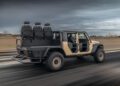 Hennessey Defense Systems unveils the WARHAWK, a modified Jeep driving down the road with three passenger seats mounted on the truck bed.